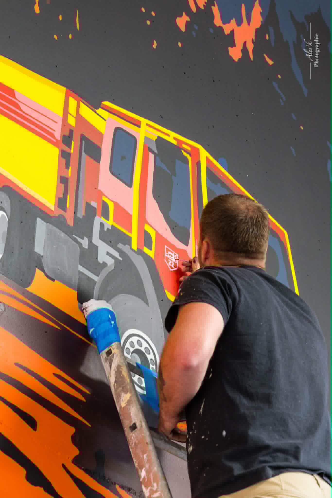 Artisan en train de peindre une fresque murale